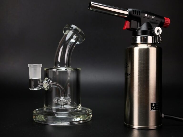 Butane dab torch next to a glass dab rig with quartz banger