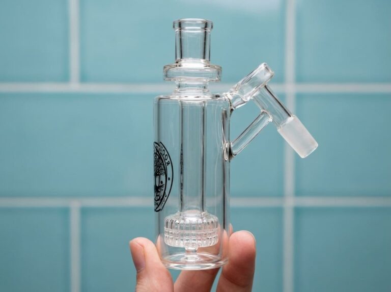 Clear glass ash catcher product shot on a soft blue backdrop