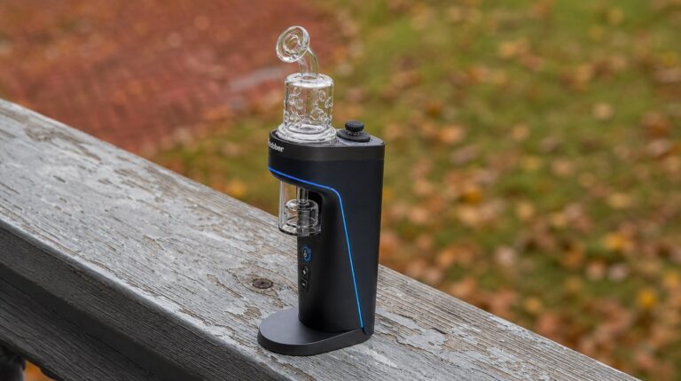 Dr. Dabber Switch 2 accessories: the Showerhead Fab glass attachment mounted on a Switch 2, shot on a weathered porch rail in soft autumn daylight.